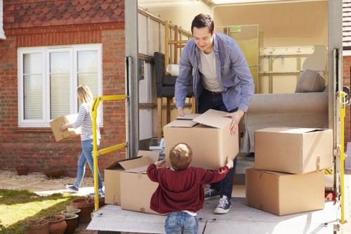 Movers carrying household furniture from a Bowespark flat with stairs