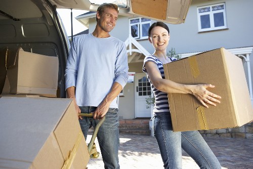 Removal staff carrying furniture through a North London property entrance